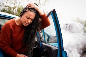 Woman holding head after a car accident