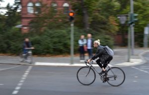 woman riding bicycle down the street